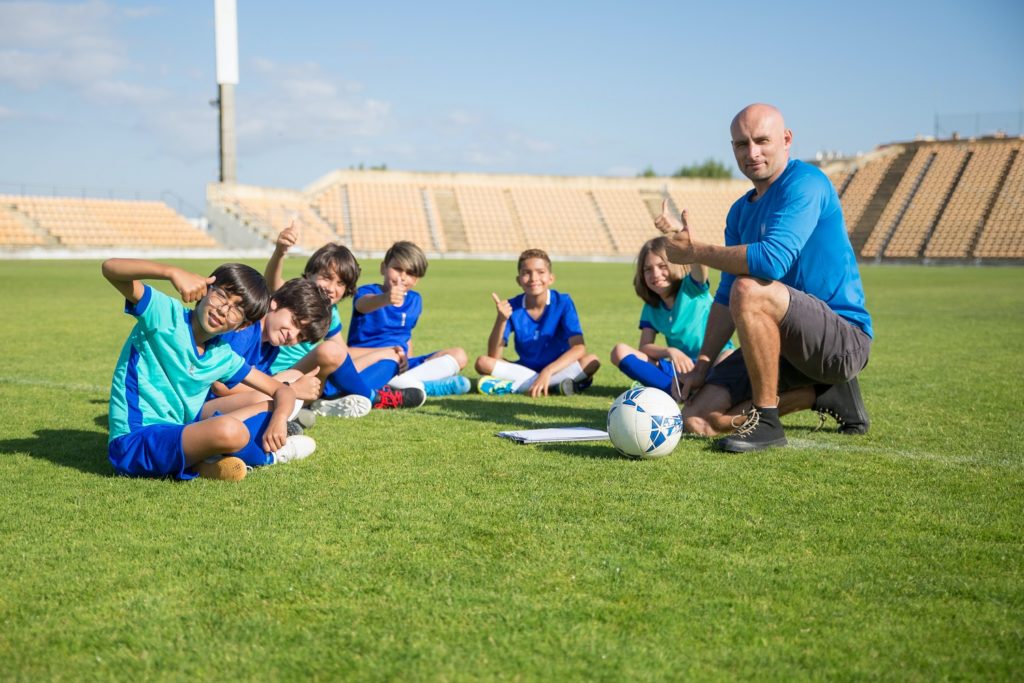 youth soccer coach with kids